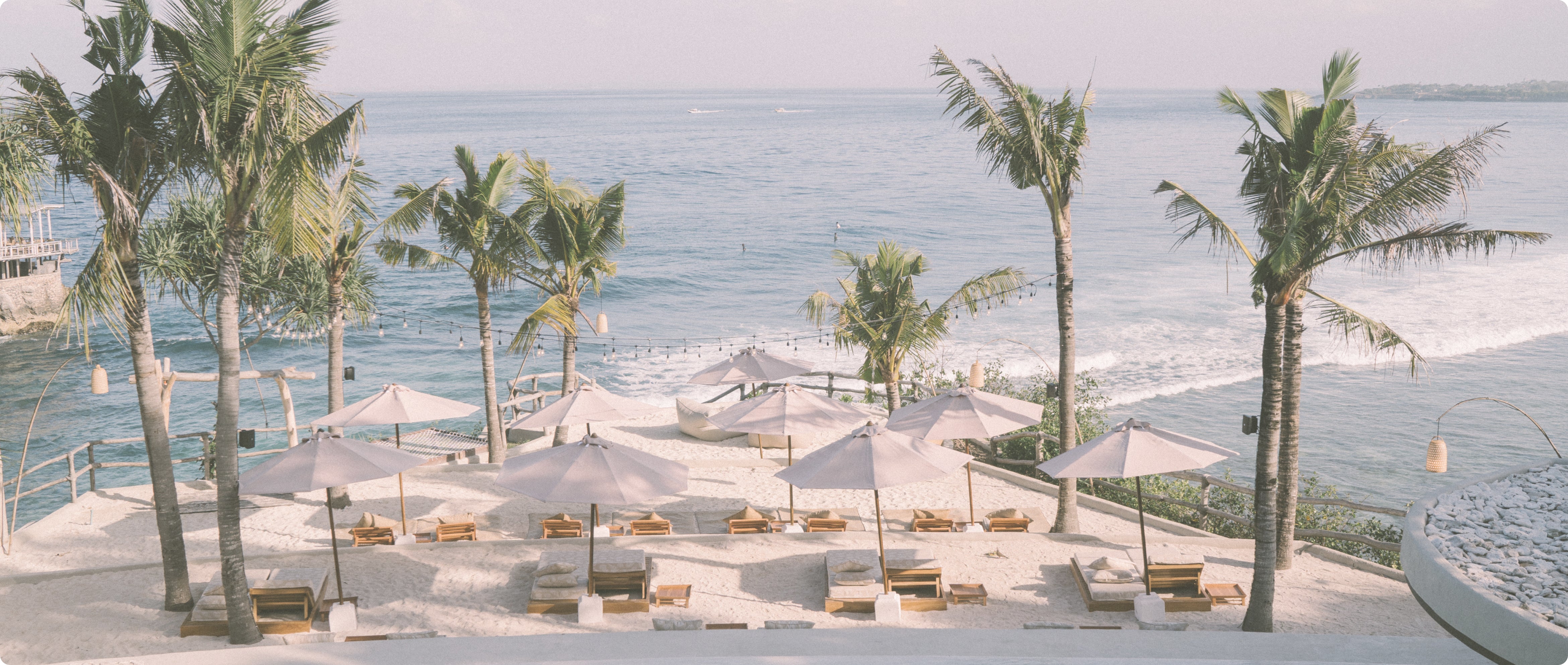 A tropical beach with vibrant umbrellas, palm trees, and a tranquil ambiance.