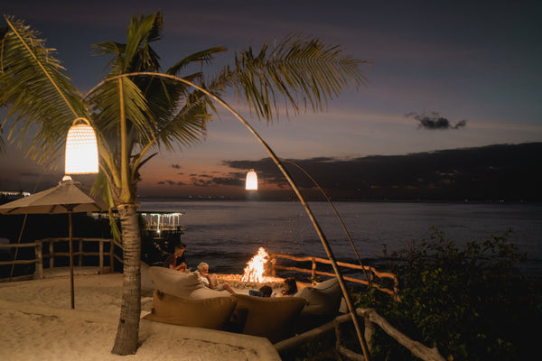 People are seated around a fire pit on cushioned seats